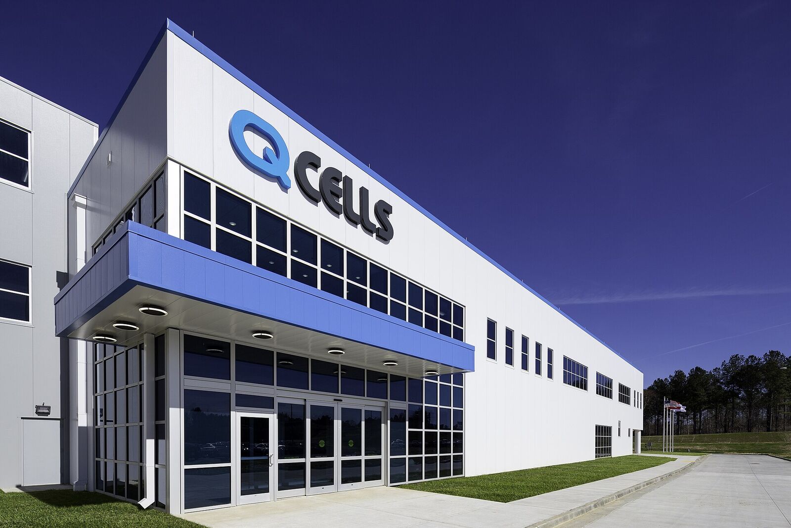 Q CELLS branded entrance of the Dalton, Georgia solar panel factory under a deep blue sky