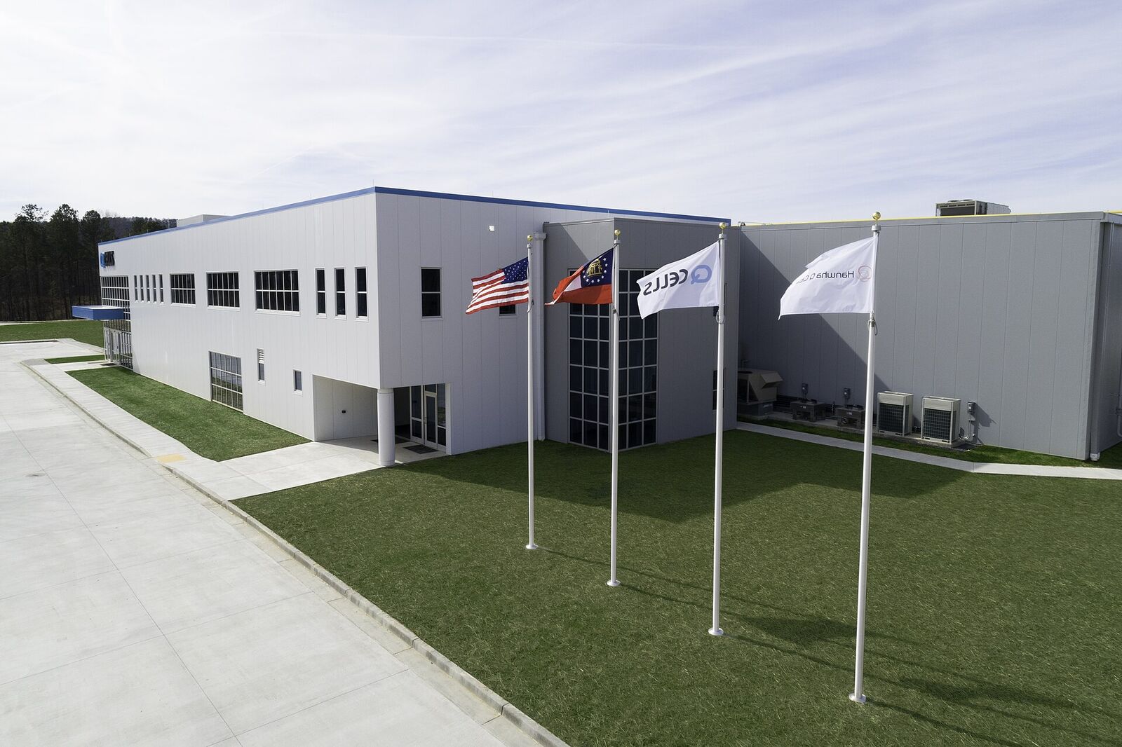 American and Georgia state flags flying at the entrance of the Qcells Dalton, Georgia factory